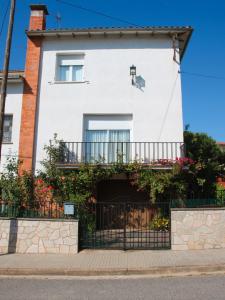 a white house with a balcony at Cal Castro fantástica casa familiar in Sant Hilari Sacalm