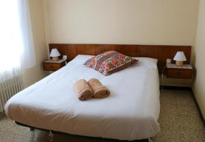 a bed with two towels on it with two lamps at Cal Castro fantástica casa familiar in Sant Hilari Sacalm