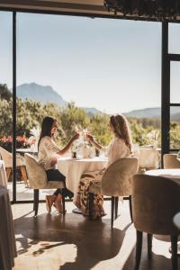 two women sitting at a table in a restaurant at Les Lodges Sainte-Victoire Hotel & Spa in Aix-en-Provence