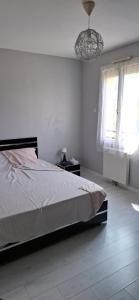 Ένα ή περισσότερα κρεβάτια σε δωμάτιο στο Maison familiale avec jardin à Le Mée-sur-Seine