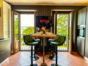 Stresa vista lago con CINEMA e SPIAGGIA في Brisino: مطبخ مع طاولة وبعض الكراسي الخضراء