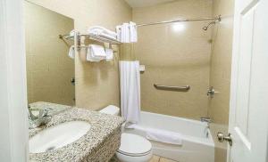a bathroom with a sink and a toilet and a tub at Carlton Motor Lodge in Los Angeles