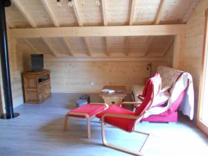 a room with a couch and a chair and a table at Le chalet du lac d'étival in Étival