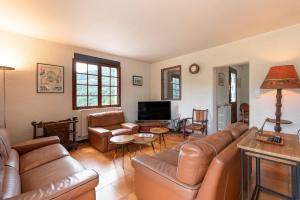 a living room with leather furniture and a flat screen tv at Villa Delb in Arthez-dʼAsson