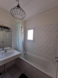 シャトライヨン・プラージュにあるT1 bord de merのバスルーム(シンク、バスタブ付)、窓が備わります。