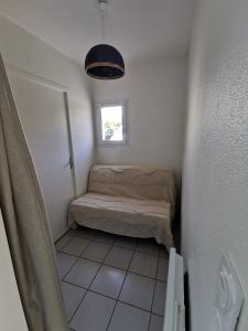 シャトライヨン・プラージュにあるT1 bord de merのベッドと窓のある小さな部屋