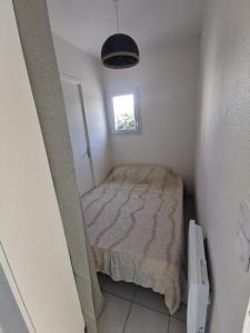 シャトライヨン・プラージュにあるT1 bord de merの窓のある小さな部屋にある小さなベッド