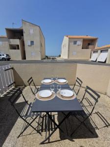 シャトライヨン・プラージュにあるT1 bord de merの青いテーブル(椅子付)、バルコニー(ワイングラス付)