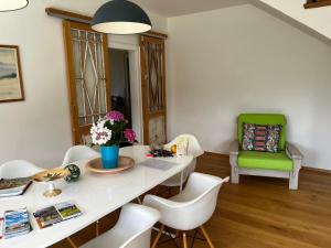 a dining room with a white table and a green chair at Golf und Berglodge Velden am Wörthersee in Köstenberg