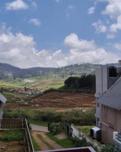 a view of a field from a house at shambhala homestay in Ooty