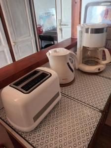 un grille-pain et une cafetière posés sur un comptoir dans l'établissement Les Hortensias, à Sangatte