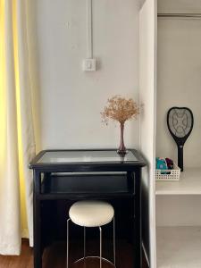 a black desk with a vase of flowers and a chair at Yellow Stay in Āīzawl