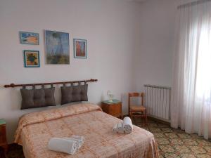 una camera da letto con un letto con asciugamani sopra di JONIA Appartamento vacanze vicino al mare con giardino a Pulsano