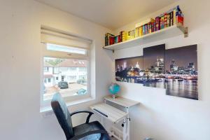 a desk and a chair in a room with a window at 3 Bed Home - 10 Min Walk to Mill Hill Tube in Hendon
