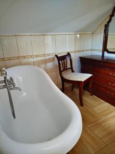 a bath tub and a chair in a room at Rezydencja Gołębiówka Mazury in Targowo +27 photos
