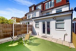a house with a patio with a table and chairs at 3 Bed Home - 10 Min Walk to Mill Hill Tube in Hendon
