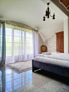 a bedroom with two beds and a large window at Rezydencja Gołębiówka Mazury in Targowo