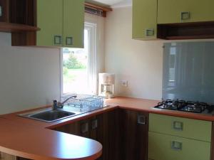 Kuchyň nebo kuchyňský kout v ubytování Mobil-home spacieux pour 6 pers avec terrasse - API-1-52-603 + 6 fotografií