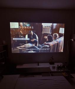 a television screen in a living room with a movie at Marienplatz Design Apartment - Historic Center in Munich