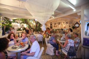 a group of people sitting at tables in a restaurant at Captain's House Hotel in Skala +34 photos