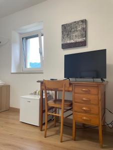 a room with a desk with a television and a chair at Locanda al Castello in Travesio