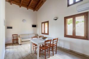 un soggiorno con tavolo, sedie e divano di Corte di Gallura a Budoni