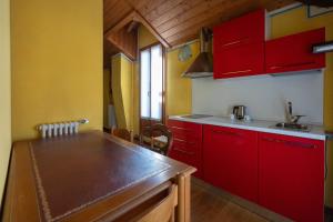 a kitchen with red cabinets and a counter top at Villa Toscanini in Stresa +62 photos
