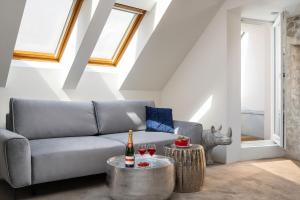 a living room with a couch and two tables at Coco Chanel Boutique Apartment by goodnite cz in Brno +5 photos