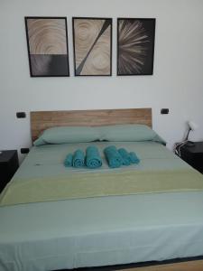 a bed with three blue pillows on it at B&B Villa Verde in Pesche