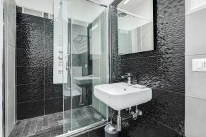 ローマにあるScipioni Best Roomsの白黒のバスルーム(シンク、シャワー付)