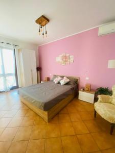 a bedroom with a bed and a pink wall at Corte del Vigneto in Montemagno