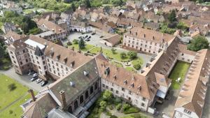 an aerial view of a large building in a city at Hôtellerie du Couvent Oberbronn in Oberbronn