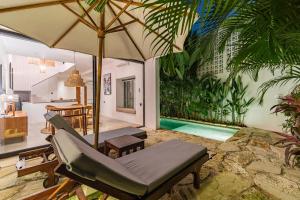 une chambre avec un hamac et un parasol et une piscine dans l'établissement Villa Castello di Quassolo, à Canggu