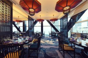 a restaurant with tables and chairs and large windows at Cinnamon Life at City of Dreams in Colombo