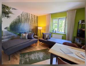 a living room with a couch and a painting on the wall at Holledauer Hopfakammerl in Wolnzach