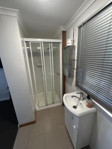 King River Caravan Park في Whitfield: حمام أبيض مع دش ومغسلة +17 صورة