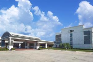 een groot gebouw met een parkeerplaats ervoor bij Hotel Gurnee in Gurnee