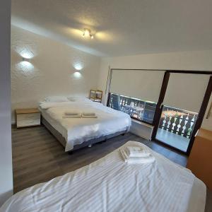 a hotel room with two beds and a large window at Cozy apartment near the Rhine in Albbruck