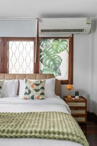 a bedroom with a bed with a green blanket on it at MIQ S22 Pool Villa PhromPhong Emsphere 5BR in Bangkok +150 photos