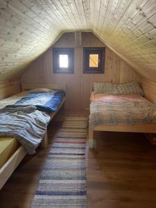 two beds in a small room in a cabin at Csanodi erdei ház in Gheorgheni