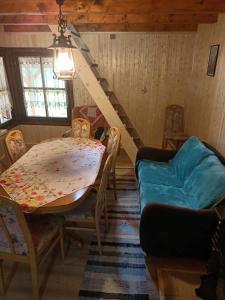 a dining room with a table and a couch at Csanodi erdei ház in Gheorgheni