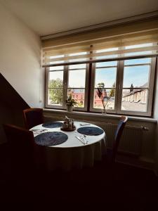 a table in a room with a large window at Penzion G in Šumperk +15 photos