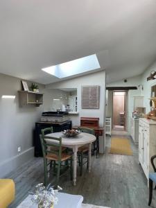 a kitchen with a table and some chairs in a room at Maison Revenu in Jalogny