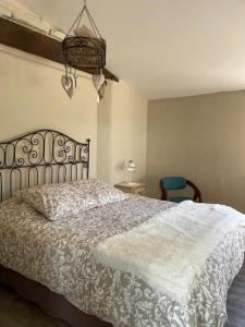 a bedroom with a bed and a chandelier at Maison Revenu in Jalogny +4 photos