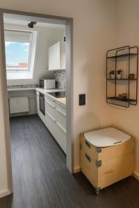 Ferienwohnung Maisonette am See في Markelfingen: مطبخ بخزائن بيضاء ونافذة