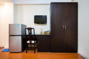 a kitchen with a refrigerator and a table with a chair at D21 KHKO Sai Gon Hotel in Ho Chi Minh City