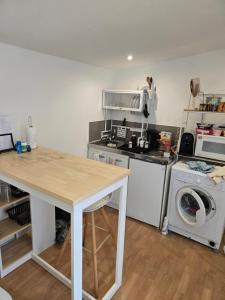 a kitchen with a table and a washing machine at Cabane pas loin de la plage in Cagnes-sur-Mer
