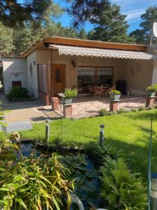 a house with a pond in the yard at Ferienbungalow Familie Eggert in Matzlow-Garwitz