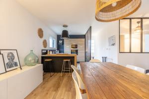 a dining room and kitchen with a wooden table and chairs at La Gergovia #Parking#Terrasse in Romagnat