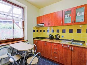 a kitchen with wooden cabinets and a table with chairs at Modern Holiday Home in Cerný Dul with Private Garden in Cerny Dul